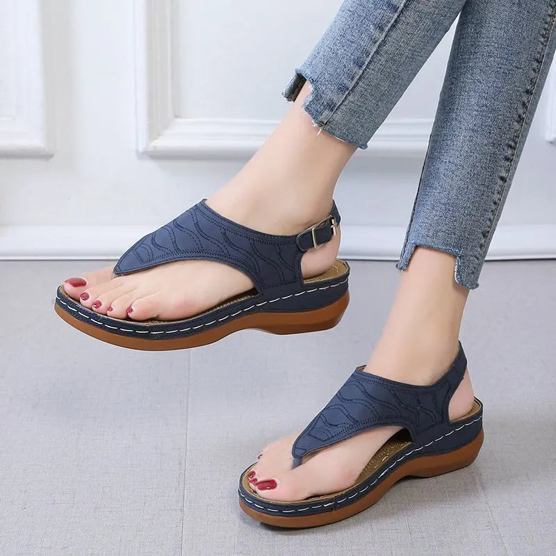 Women's wedge heel flip flop sandals with an adjustable back strap in solid black.