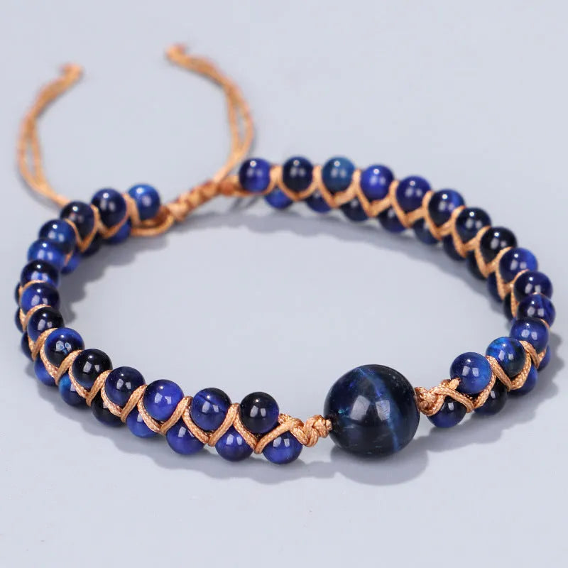 Close-up of a handmade geometric bracelet woven with blue Tigereye stone beads, showing its textured pull-on design.