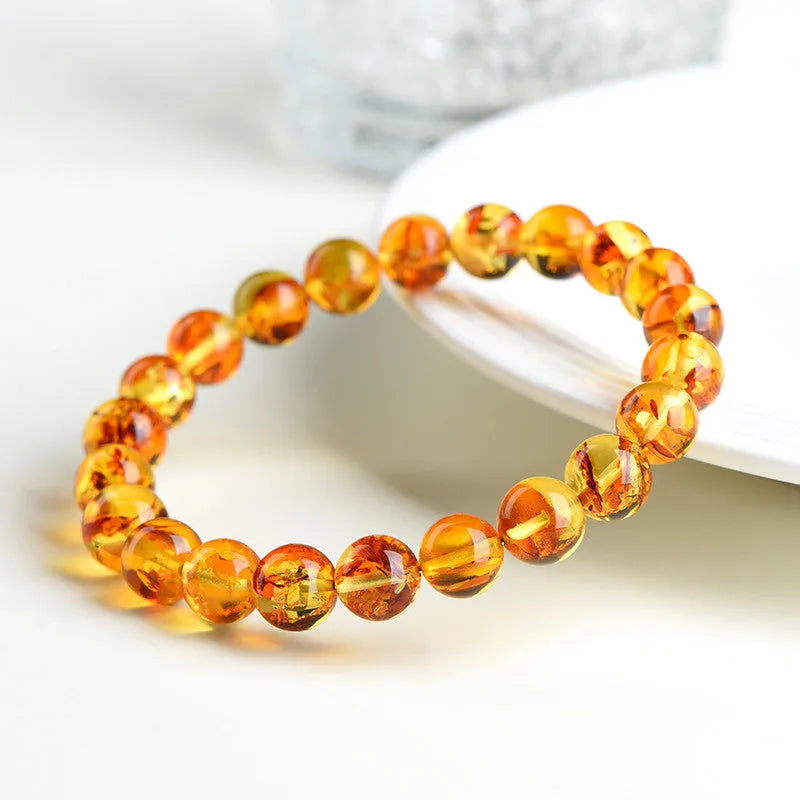 Natural yellow piebald amber bracelet with geometric design on a wrist.