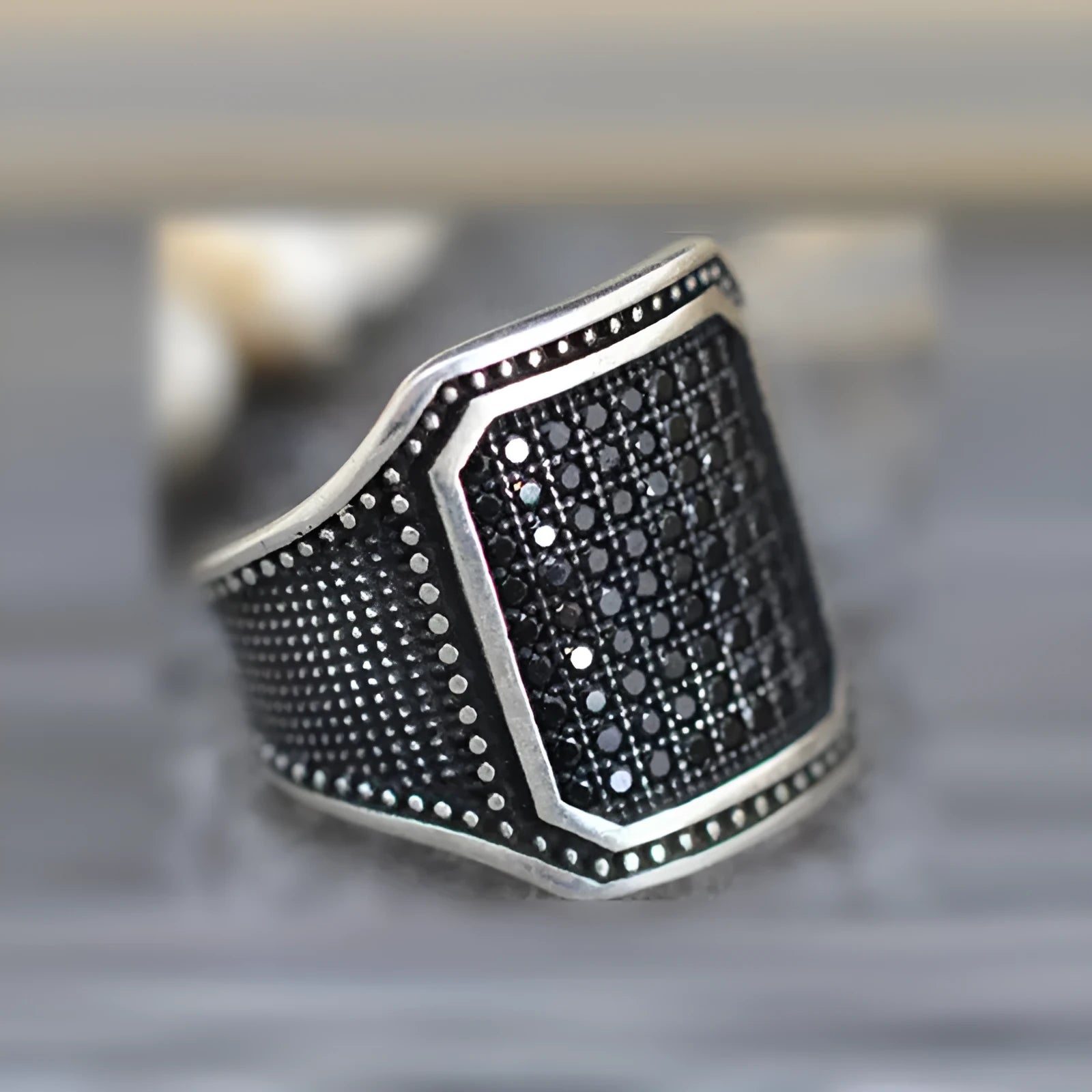 Matte black adjustable ring with a clear zircon stone and copper metal inlay detail on a plain background.