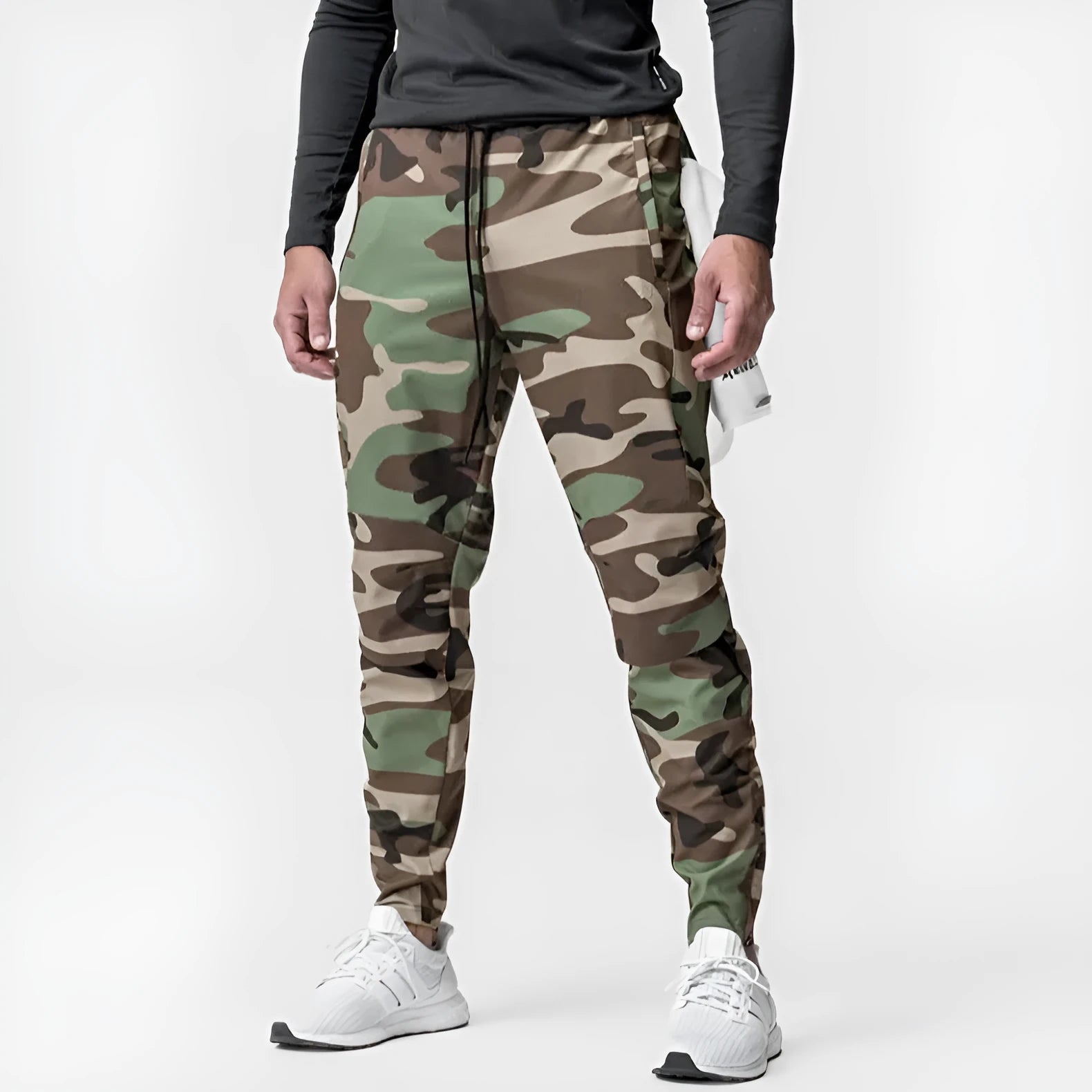 Man wearing dark grey tapered fitness trousers with adjustable ankle ties during a workout.