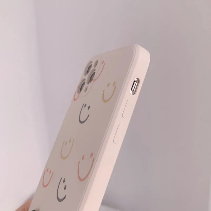 Simple silicone TPU iPhone case with a painted smiley face design on a solid colour background.