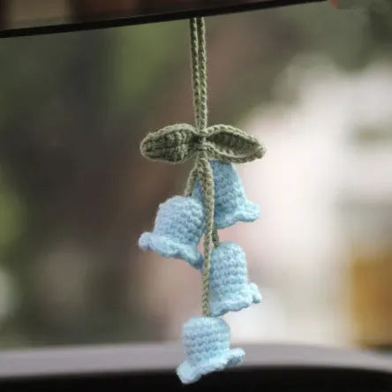 Green and white knitted wool car plant ornament hanging from a rope