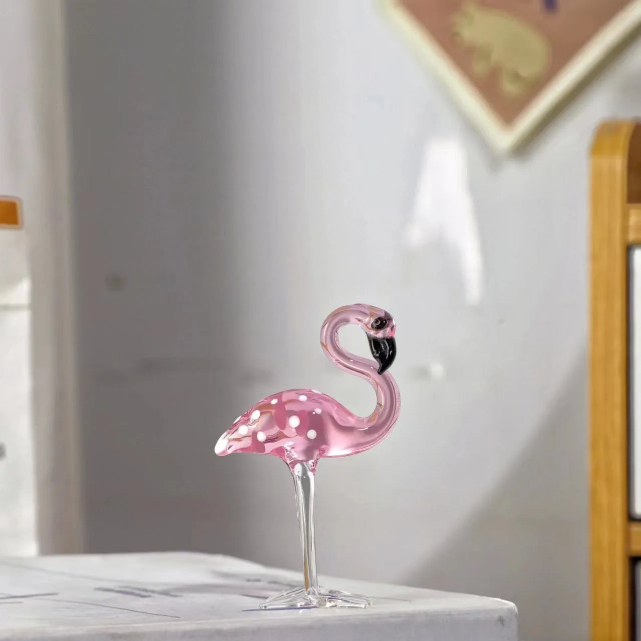Pink flamingo crystal decorative ornament on a table in modern minimalist style.