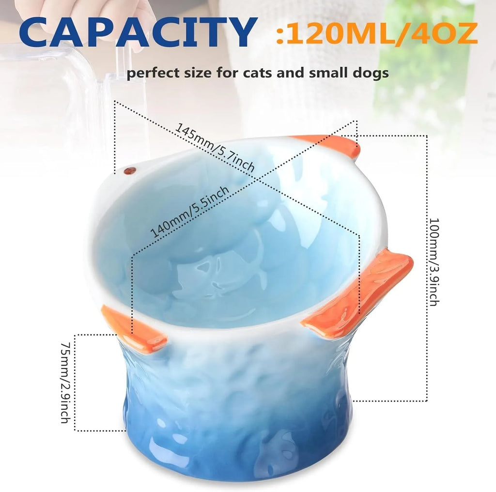 Blue ceramic fish-shaped cat bowl with tilted design and non-slip base on a wooden surface