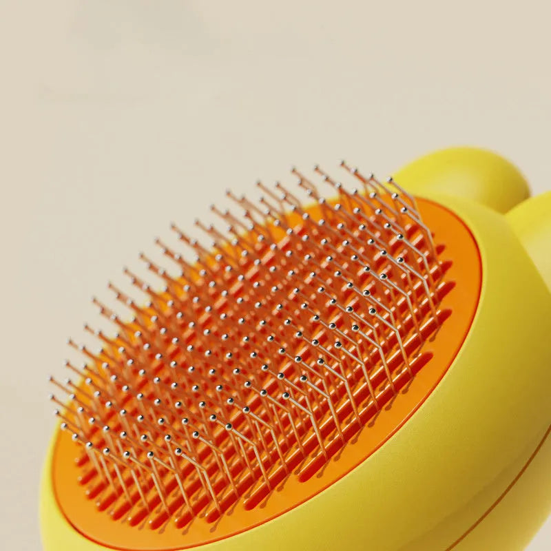 Self-cleaning pet hair brush with release button and rubber-tipped metal pins for cats and dogs.