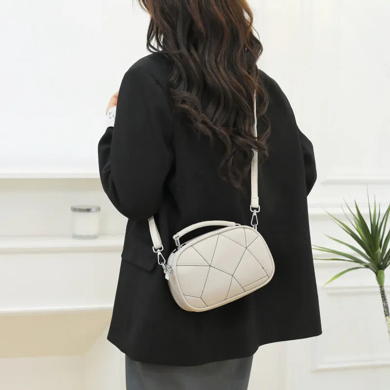 Round PU leather crossbody bag with patchwork design showing decorative stitching
