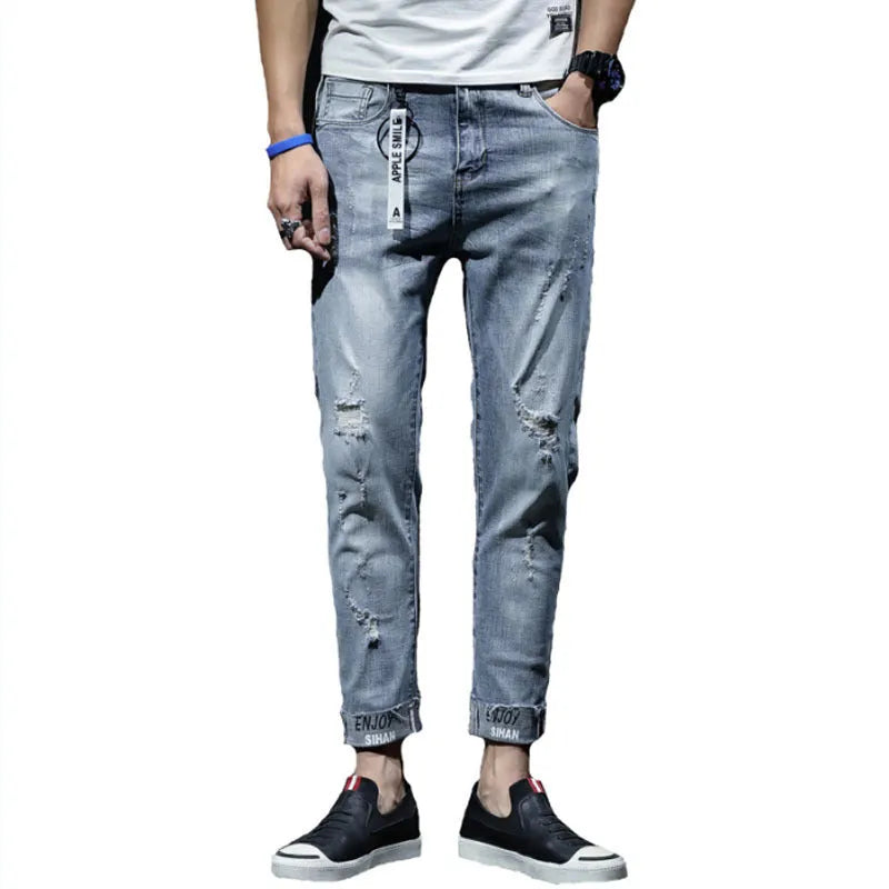 Light blue denim cropped jeans with ripped details on straight leg