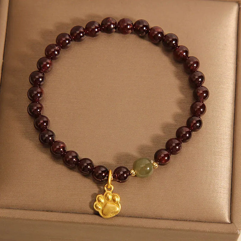 Women's Cat's Paw Garnet crystal bracelet on wrist, original design.