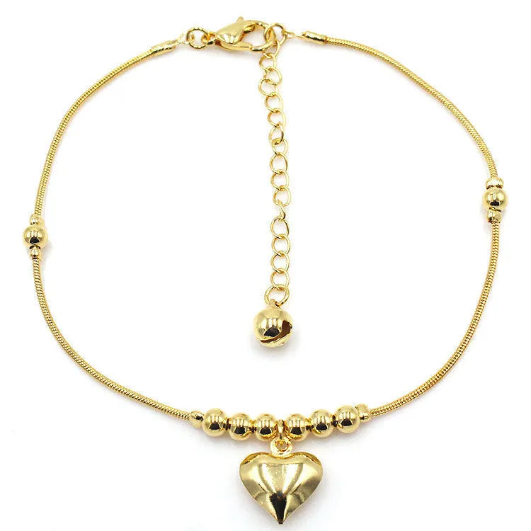 Gold colour gothic heart pendant anklet on a woman's ankle with chunky ball beads and copper chain 27cm