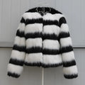 Long-sleeved black and white striped faux fur jacket for women on a grey background.