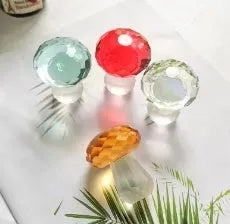 Colourful mushroom-shaped crystal decoration in geometric style on a surface, showing light green hue.