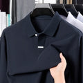 Man wearing a grey loose-fit cotton polo shirt with asymmetric lapels and long sleeves.