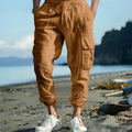 Man wearing loose-fit khaki linen casual trousers with ankle ties and multiple pockets.