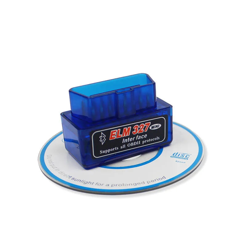 Small black OBD2 Bluetooth scanner car diagnostic code reader next to a vehicle's diagnostic port.