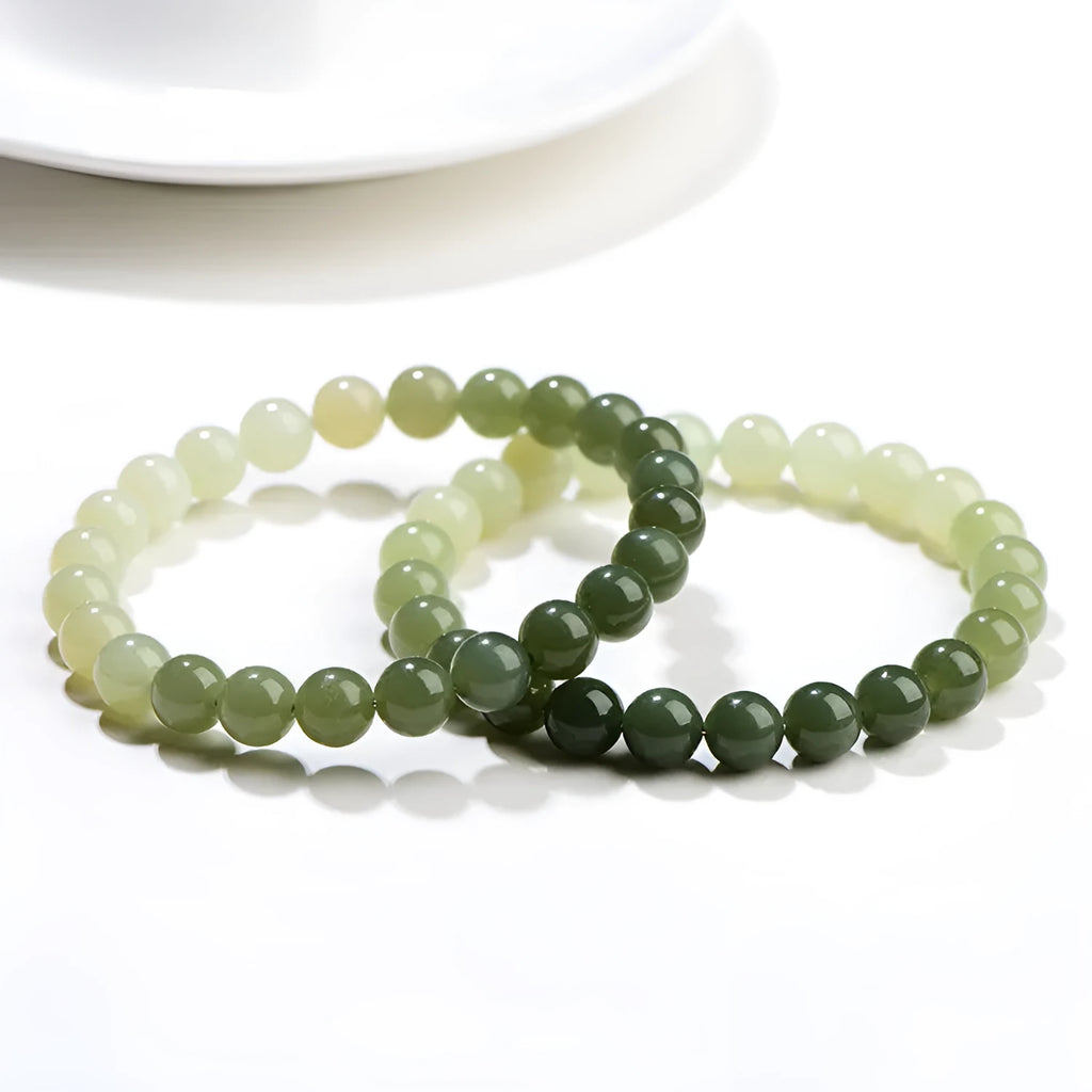 Natural clear water Hetian jade bracelet with gradient round beads on a wrist.