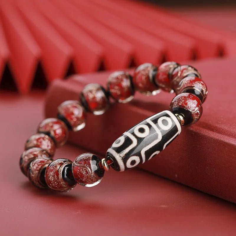 Close-up of a handmade Chinese-style bracelet with coloured glaze lucky beads on a snake theme.