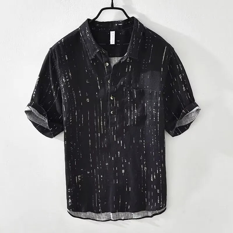 Man wearing a loose fit black short-sleeved polo shirt with a lapel collar, cardigan style.