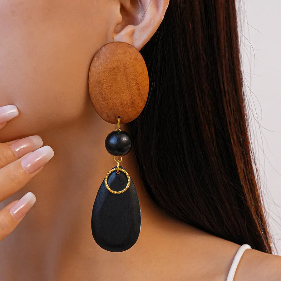 Wooden drop earrings with oval ellipse shape and silver needle accents in brown black colour
