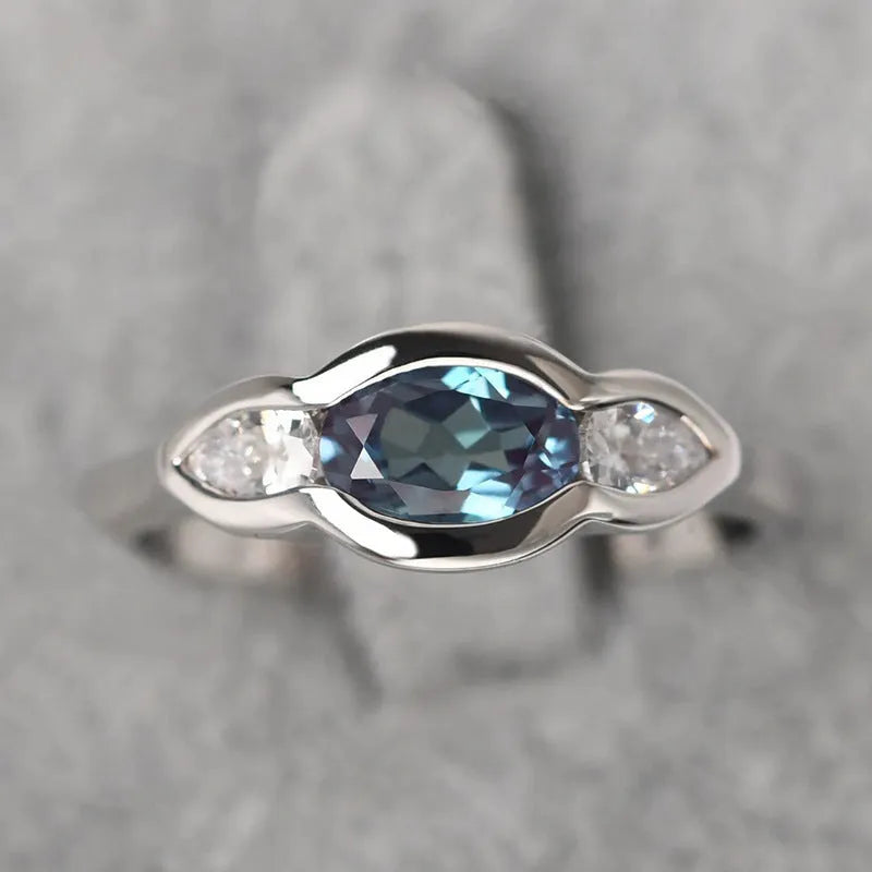 Geometric ellipse copper ring with inlaid zircon stone in a white gold tone colour.
