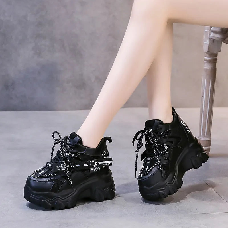 White and black women's low-top platform sports shoes with mesh upper and cross strap.