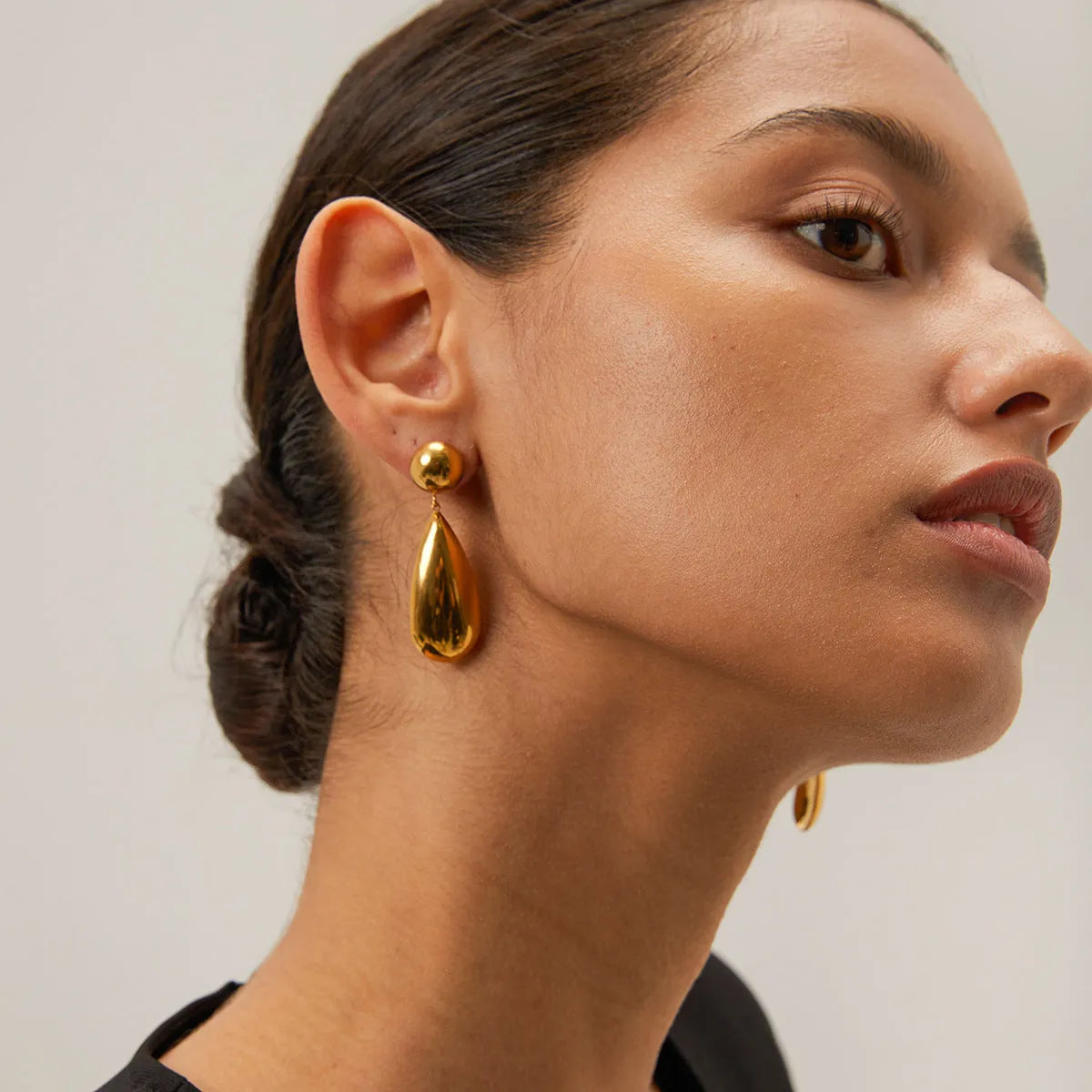 Gold-colour stainless steel pendant earrings with geometric hemisphere and water drop design.