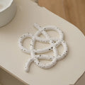 Modern irregular-shaped ceramic heat proof mat in grey protecting a wooden dining table from a hot pan.