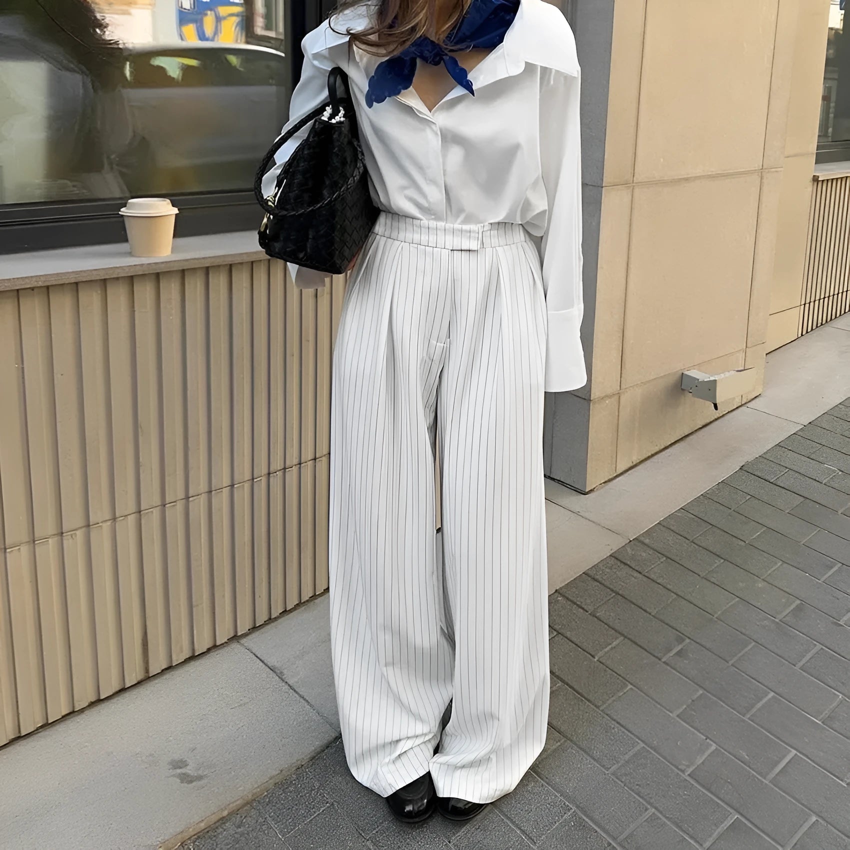 White striped wide-leg women's trousers with a front zip on a hanger.
