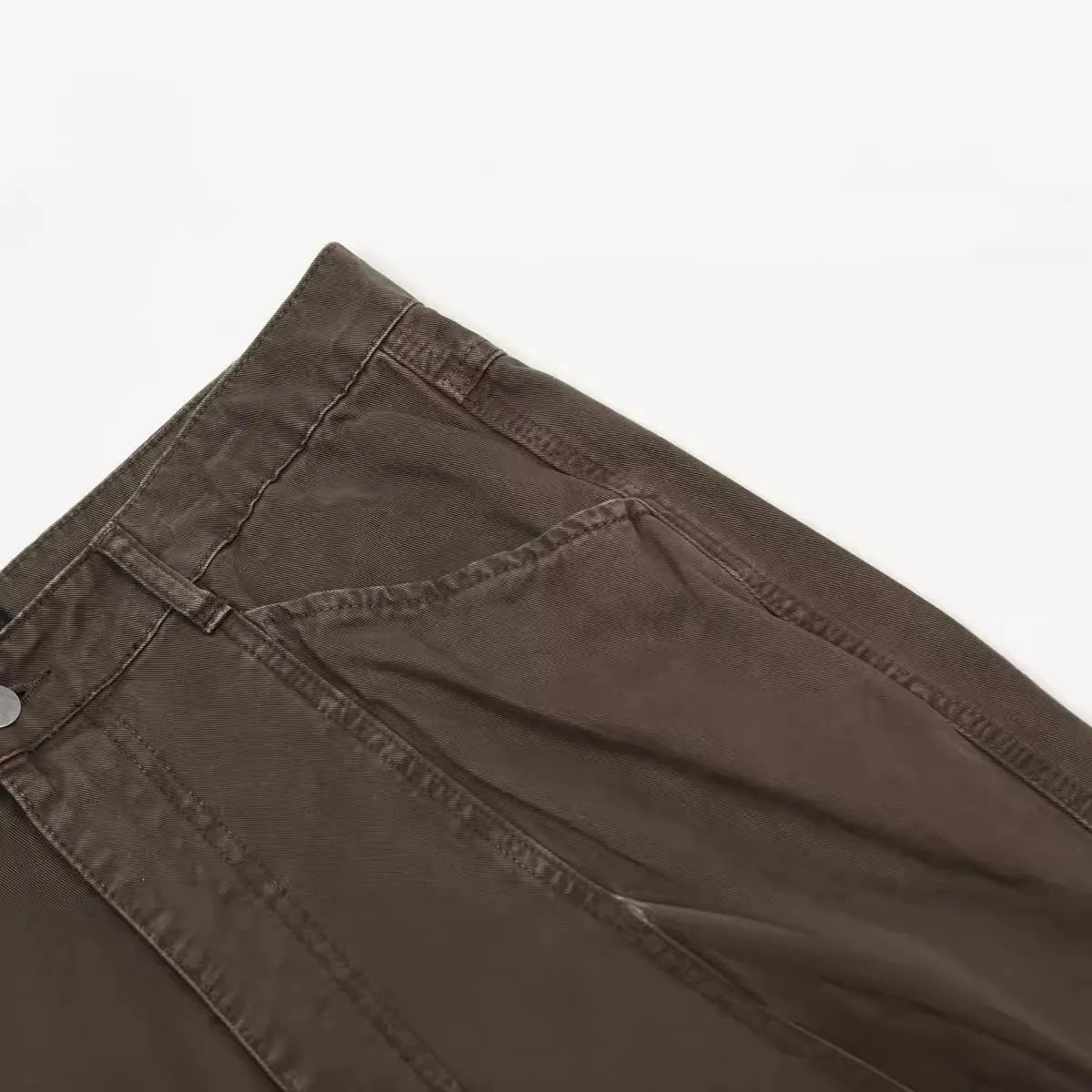 Men's brown loose-fit straight leg trousers with a high waist and wide-leg style on a hanger.