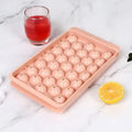 Blue silicone ice cube tray with lid showing 33 round grids for making ice.