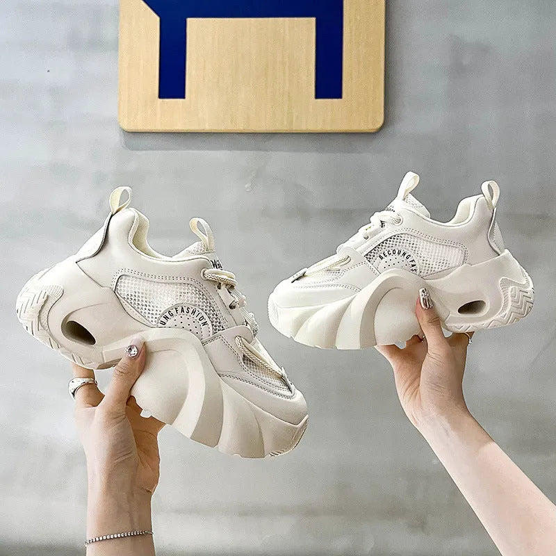 Women's pink casual sneakers with a thick sole, cross-strap detail, and lace-up closure on a white background.