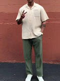 Green men's pleated casual trousers showing ankle-length cut and regular fit