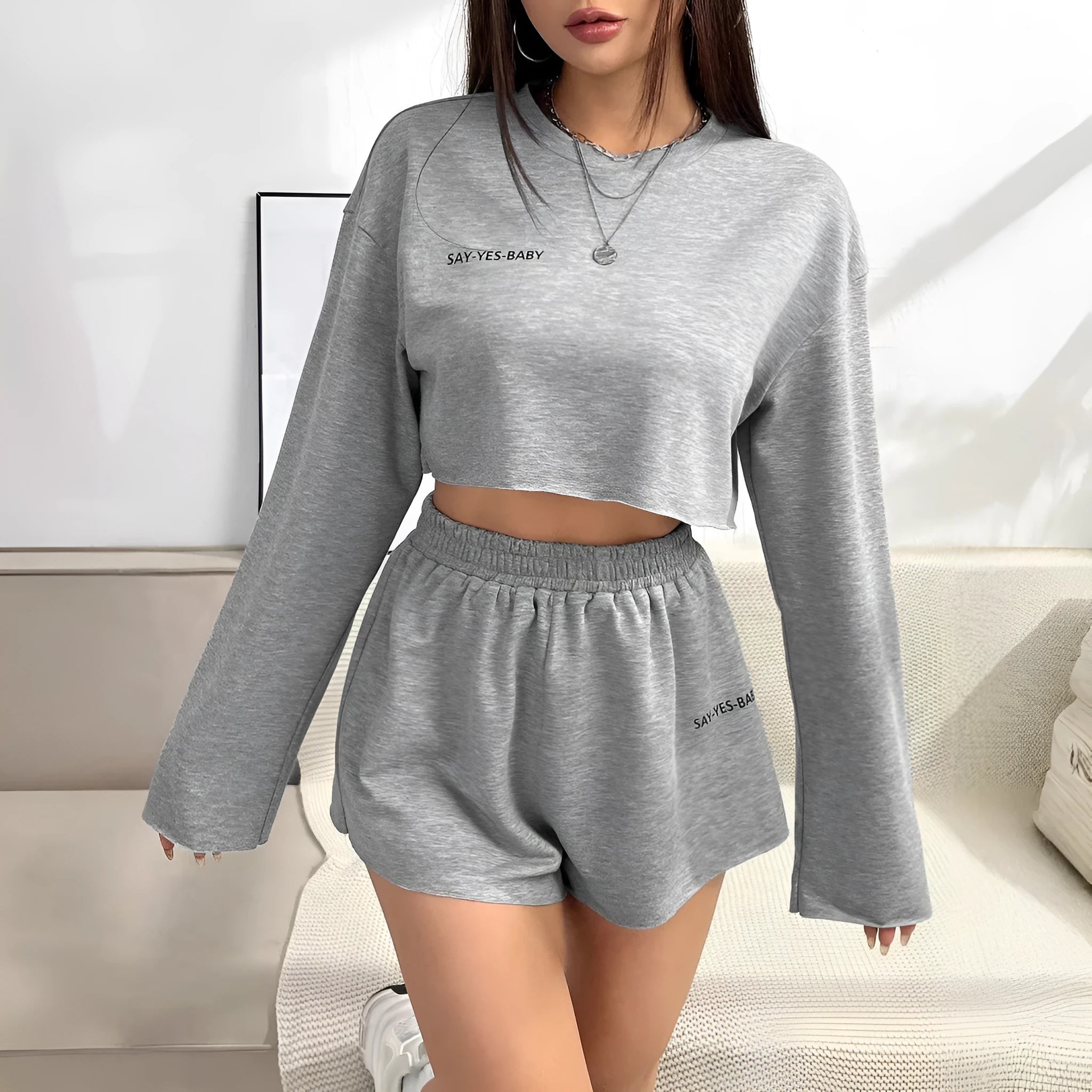 Grey women's long-sleeved T-shirt and matching shorts sleepwear set laid flat