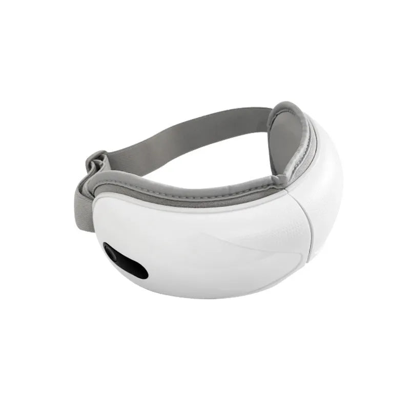 White rechargeable eye massager with hot compress and airbag massage functions on a table