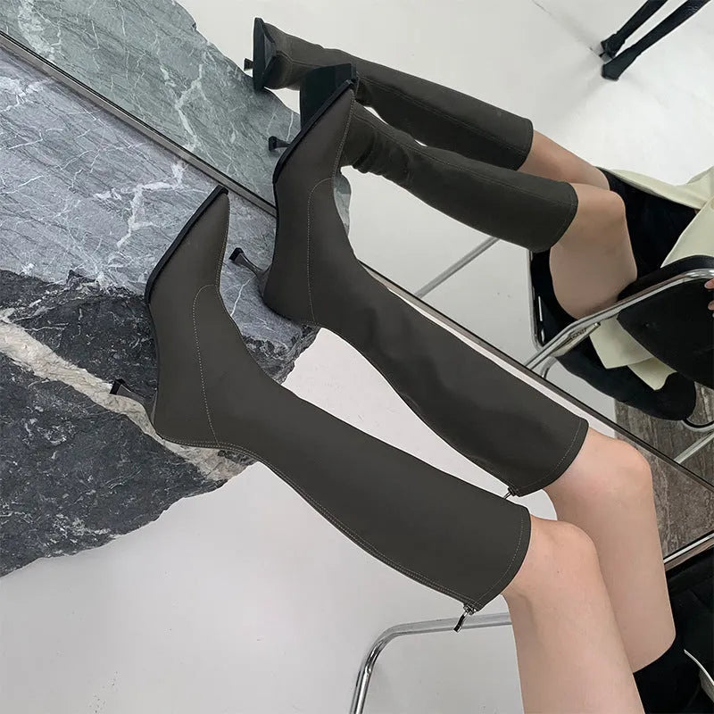 Women's black pointed toe stiletto boots with a back zipper, shown from the side.