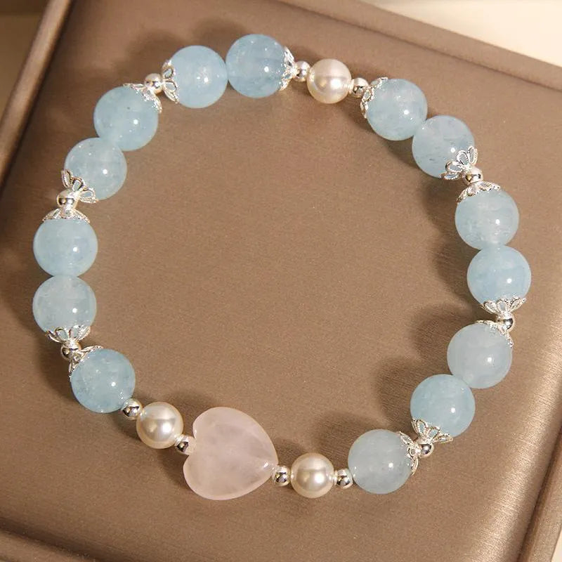 Natural aquamarine crystal bracelet with three shell pearls and lobster clasp on display