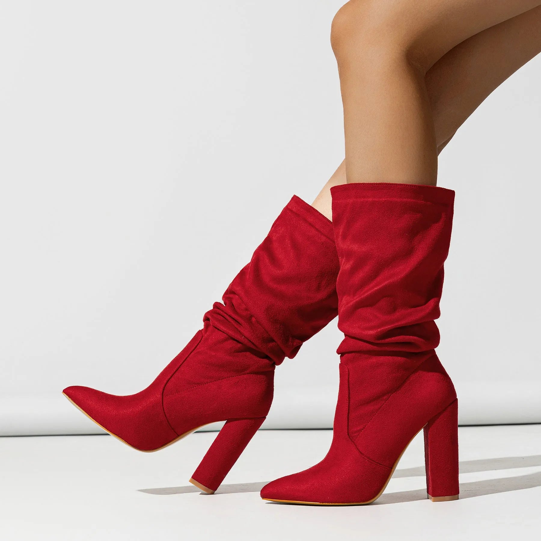 Women's black suede chunky heel pointed toe ankle boots with a high heel, shown from the side.