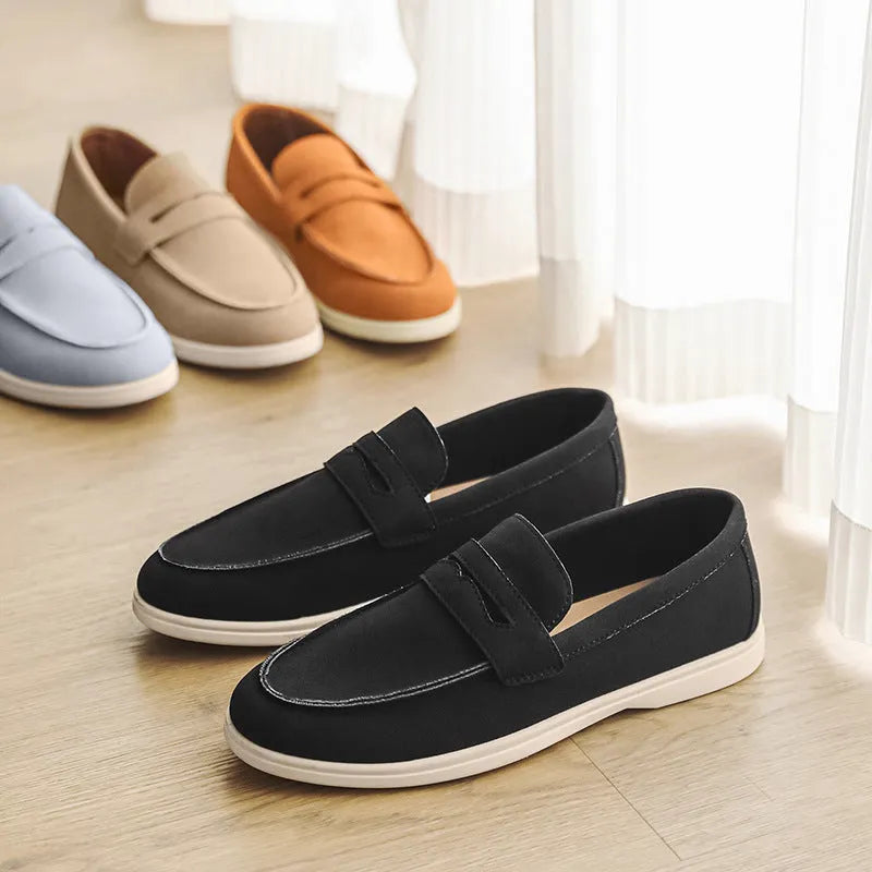 Men's beige suede British style casual slip-on shoes with a round toe and low flat heel on a rubber sole.