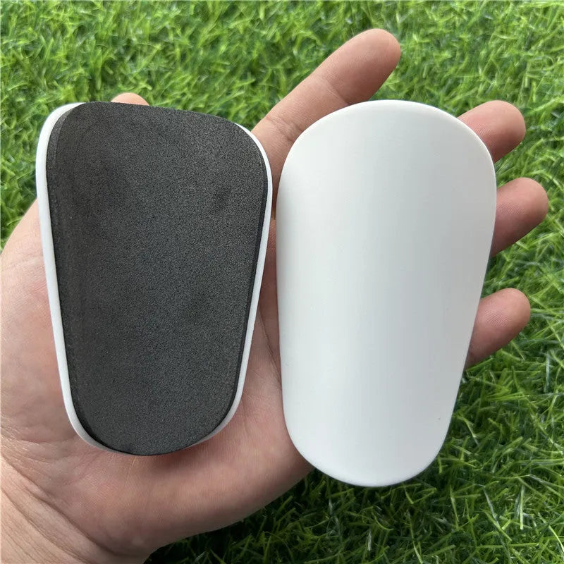 Extra small mini football shin guards in black and white, measuring 8x5cm