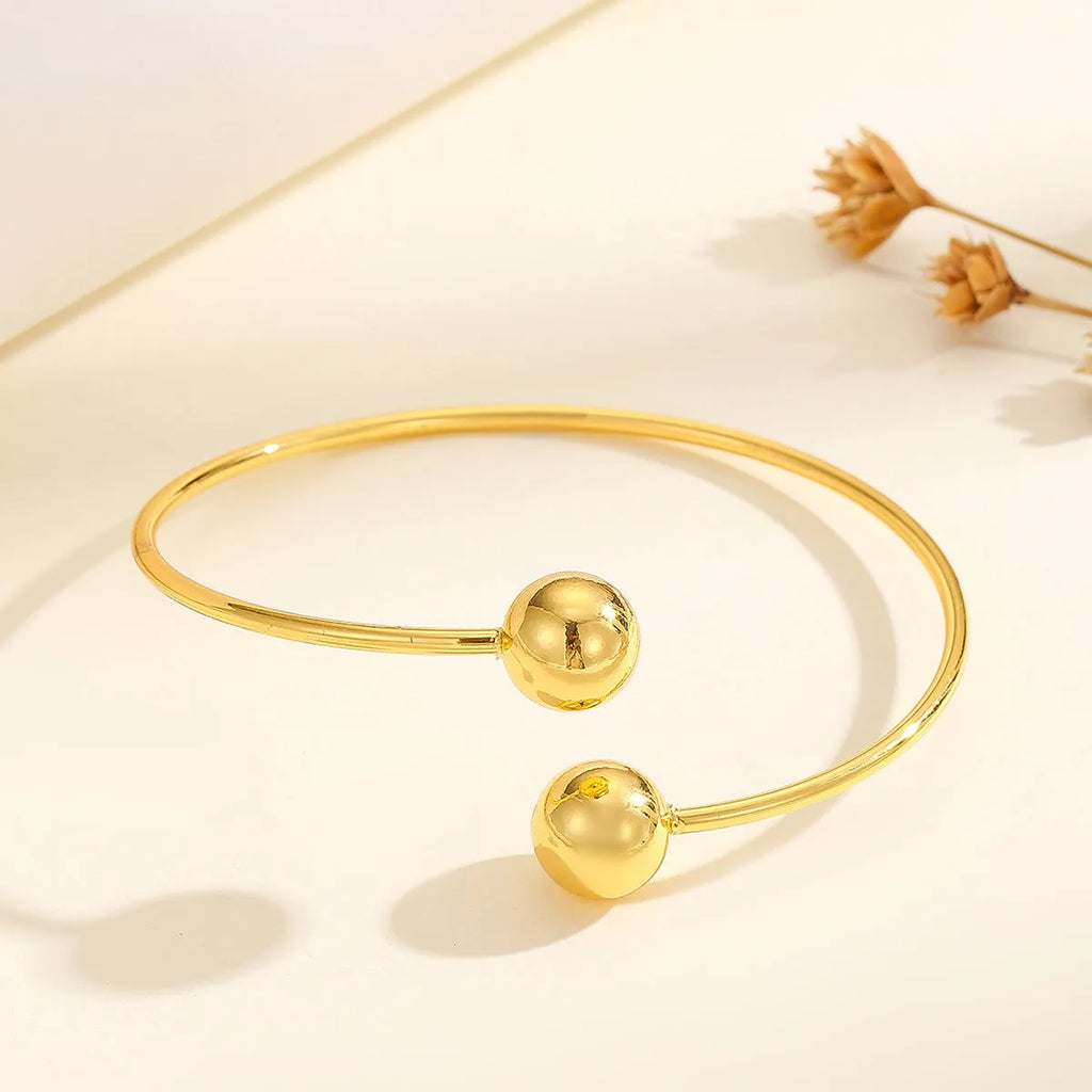 Golden copper plated 18k gold double bead opening bracelet on white background