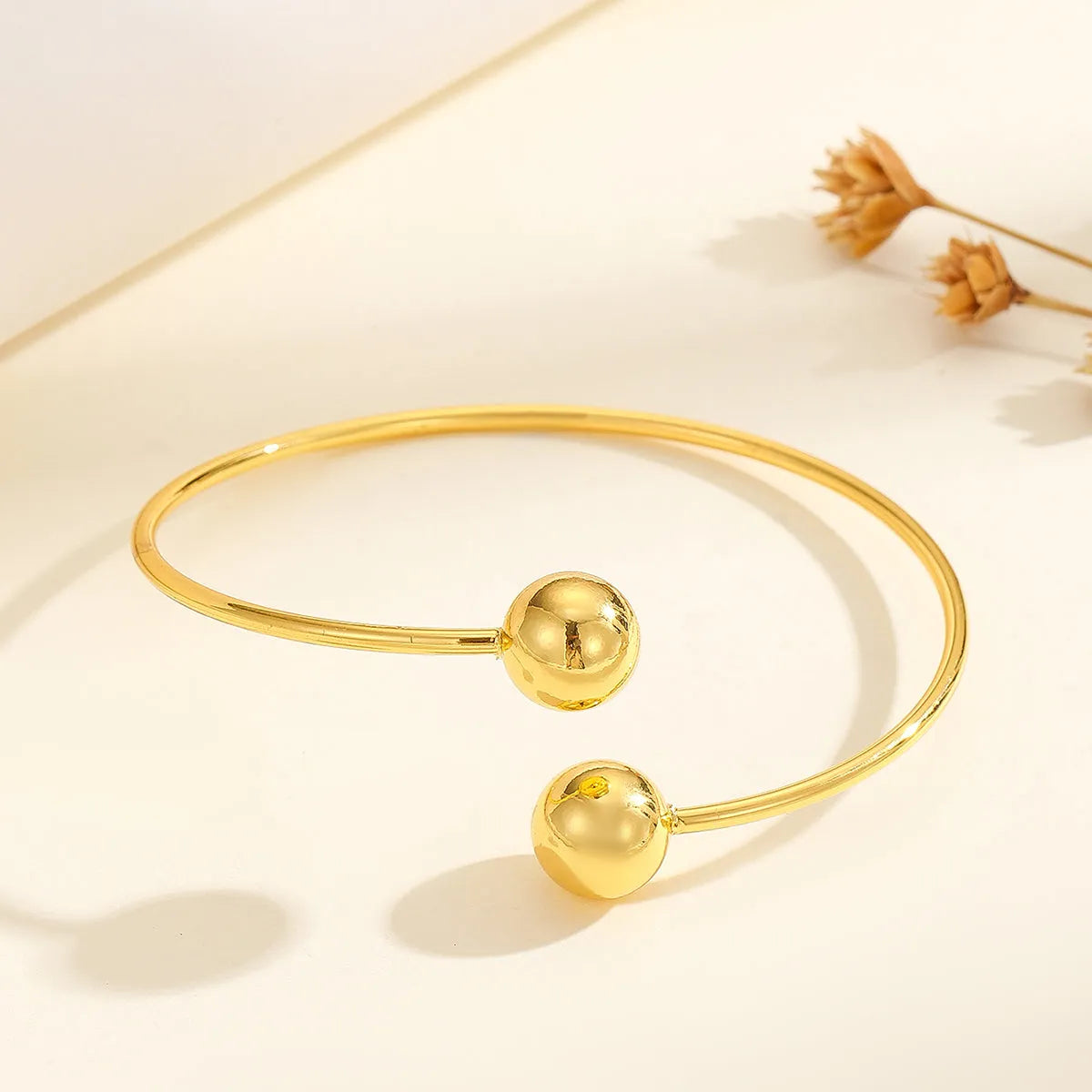 Golden copper plated 18k gold double bead opening bracelet on white background