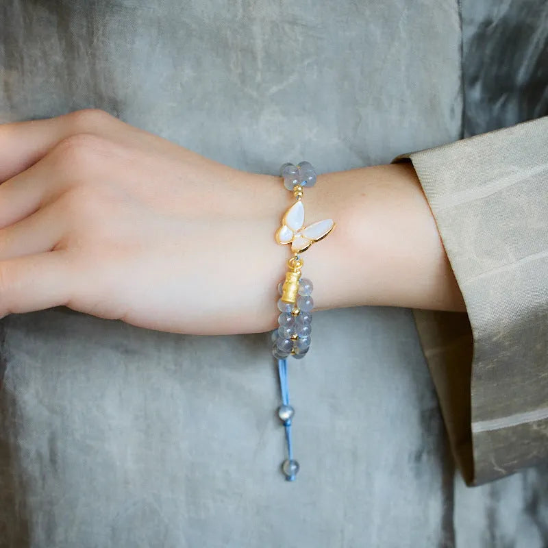 Grey moonstone woven bracelet with butterfly pattern and silver tone clasp