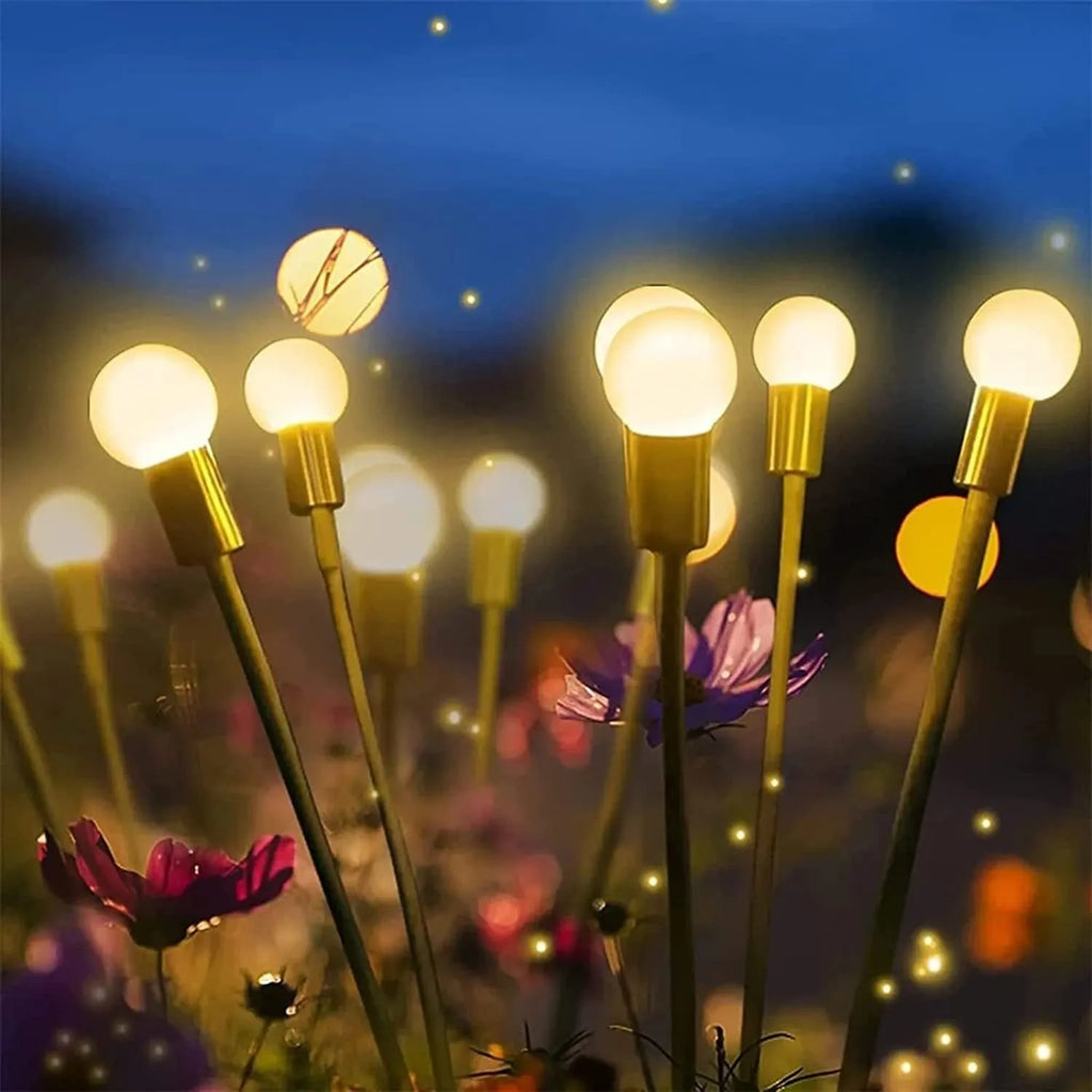 Solar-powered LED garden stake light with automatic sensor, shown pushed into soil beside plants.