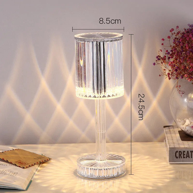Modern crystal table lamp with transparent bead shade and metal stand on wooden surface