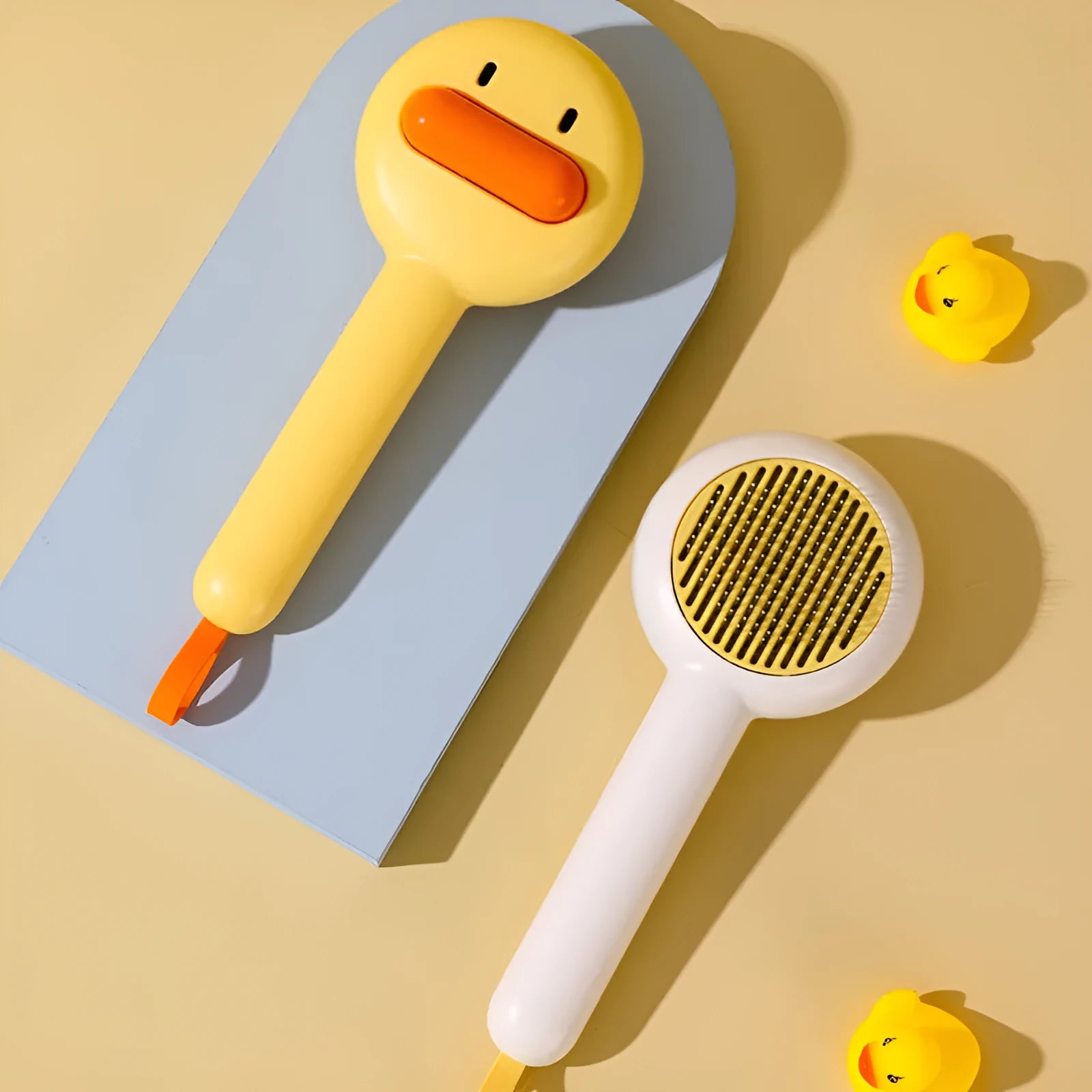 Small yellow duck-shaped pet comb for cat and dog grooming with open-section needle design