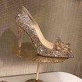 Women's gold high heels with pointed toe, rhinestone decoration, and a stiletto heel.