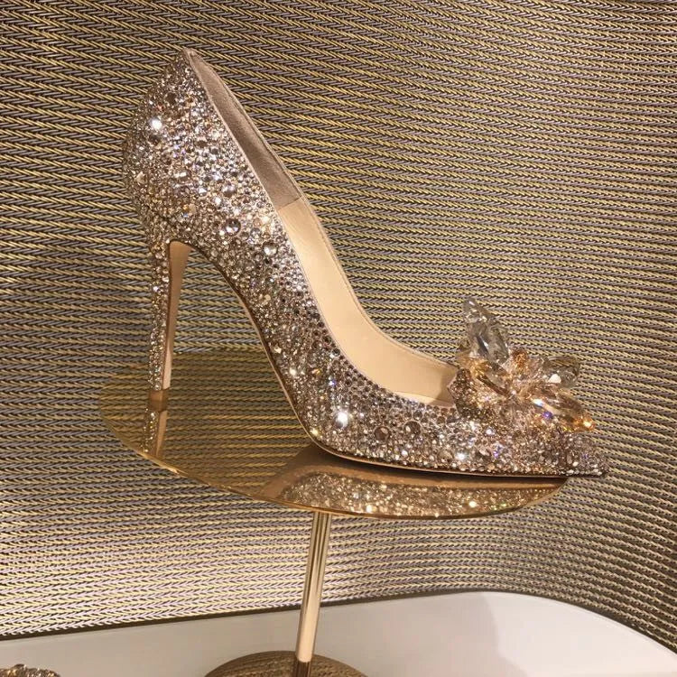 Women's gold high heels with pointed toe, rhinestone decoration, and a stiletto heel.