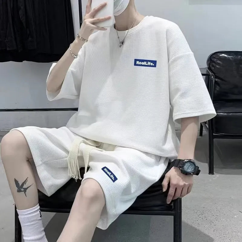 Men's waffle texture leisure set comprising a grey short-sleeve T-shirt and matching shorts on a hanger.