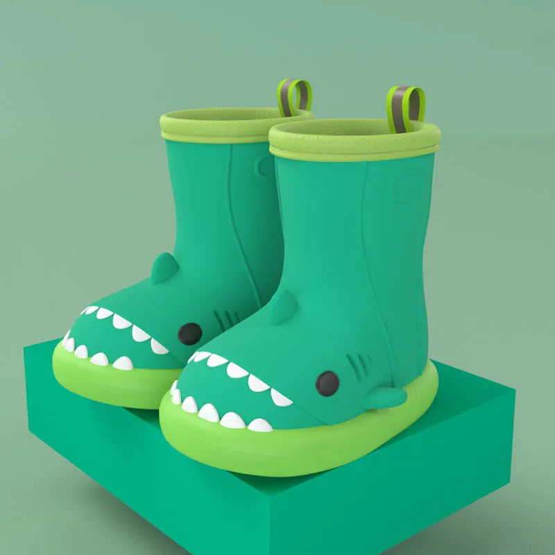 Shark brand children's green rain boots with a dinosaur graphic, showing medium height and plastic construction.