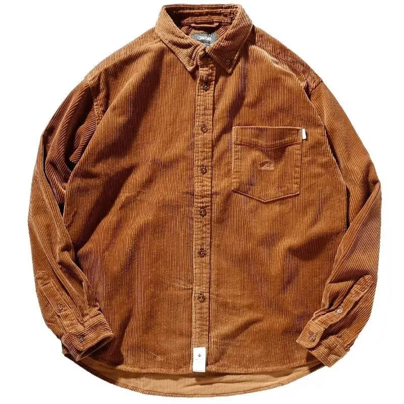 Caramel coloured loose fit corduroy cardigan shirt with long sleeves on a hanger.
